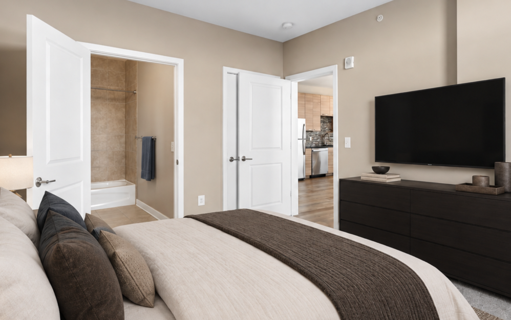 Furnished bedroom with modern decor, wall-mounted television, and neutral finishes at The Swift at Petworth apartments in Washington DC.