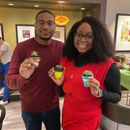 a man and a woman holding tiny plants