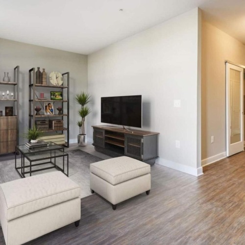 a living room with a tv, couch and chairs