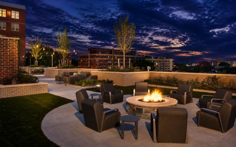a courtyard with a fire pit and chairs