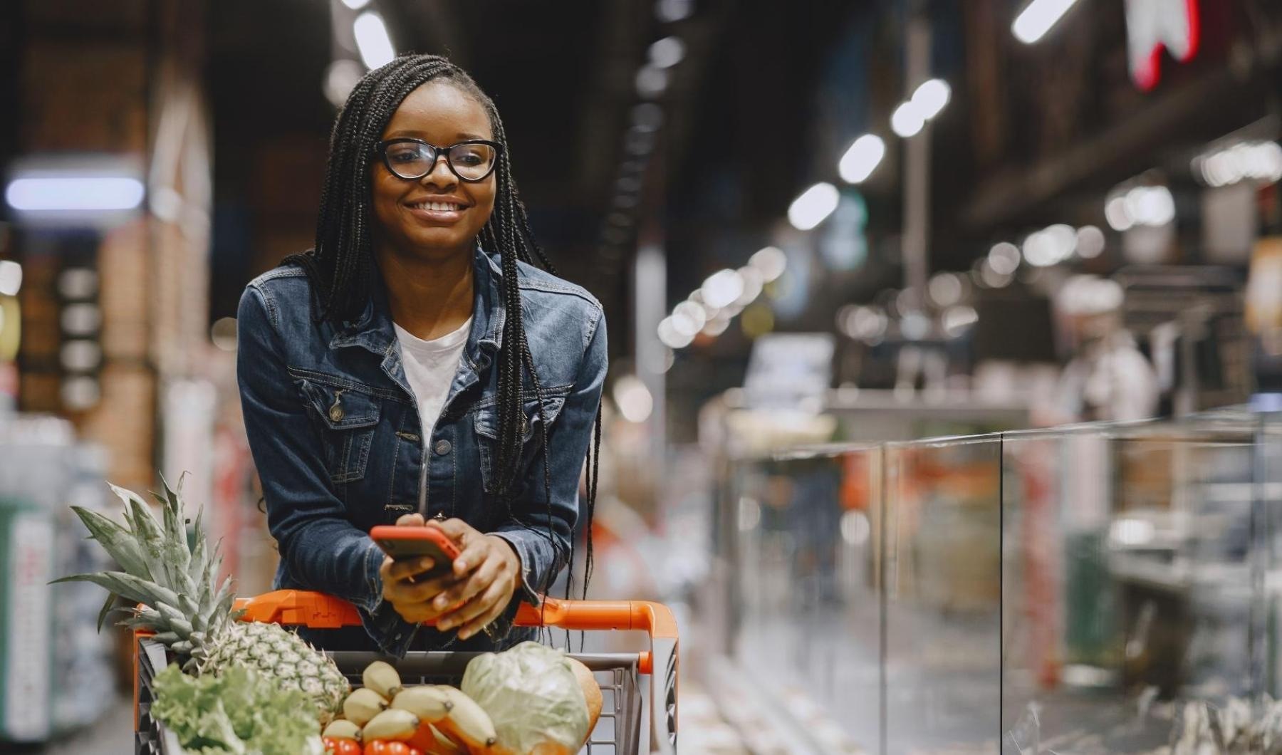 a person pushing a cart with food in a store